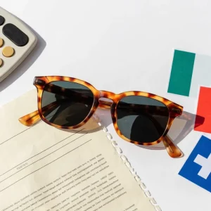 import custom sunglasses from China — tortoiseshell acetate frame beside shipping document calculator and destination market cards