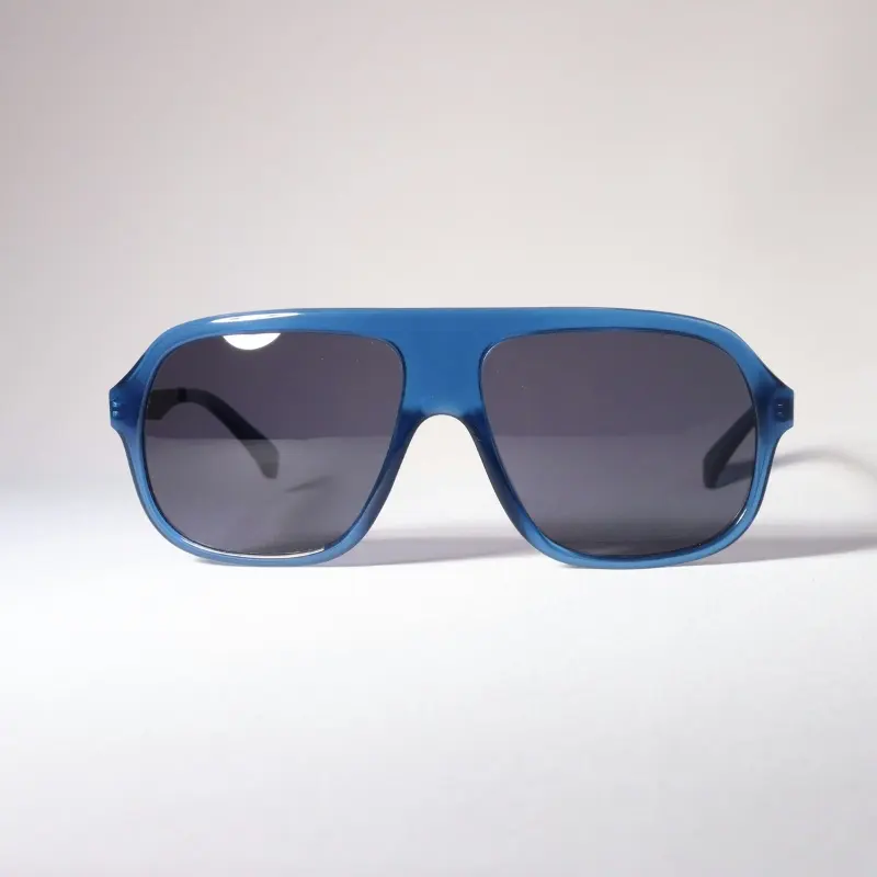 Blue translucent oversized aviator-style sunglasses with dark lenses and black temples on white background