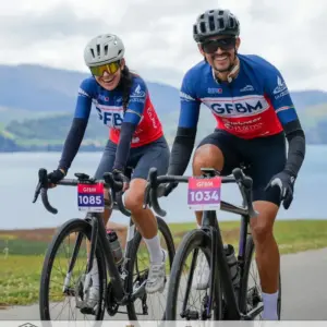 Two cyclists wearing custom private label sports sunglasses and helmets during a road cycling race