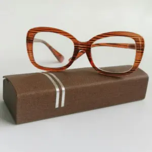 Striped acetate reading glasses resting on a branded fabric eyewear case, representing frame MOQ and packaging planning for brands