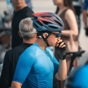 Cyclist wearing a helmet and sports sunglasses adjusting the eyewear before a ride