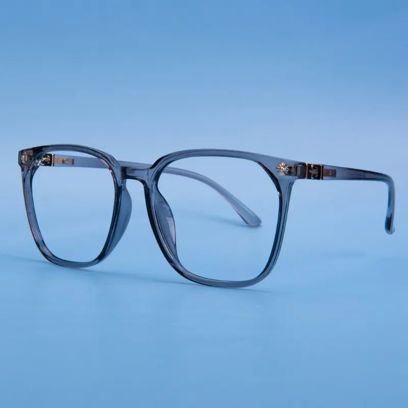 Translucent blue-gray acetate optical frame with clear lenses and decorative metal hinge hardware on a blue background